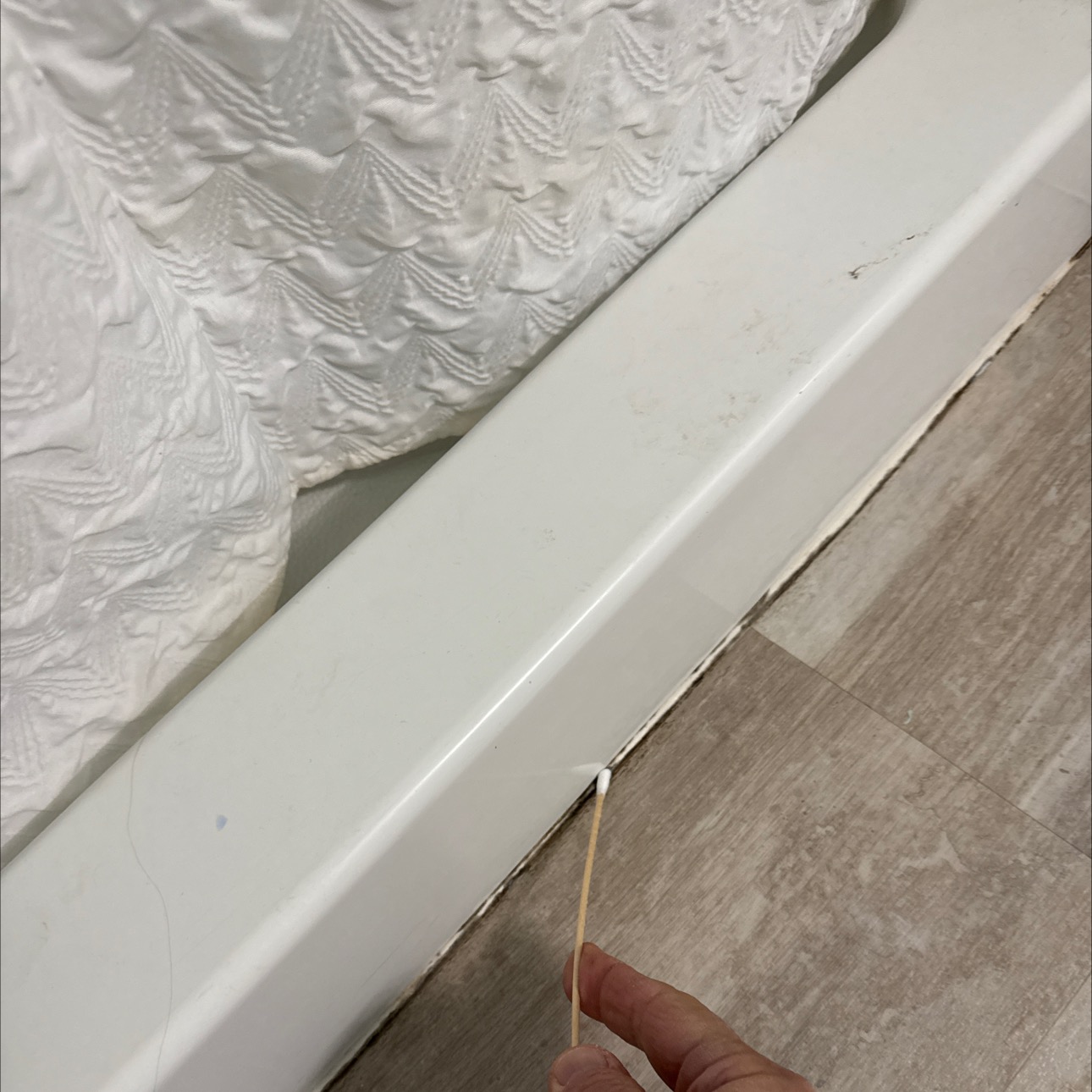 Close-up of moldy latex caulk around a shower in a bathroom